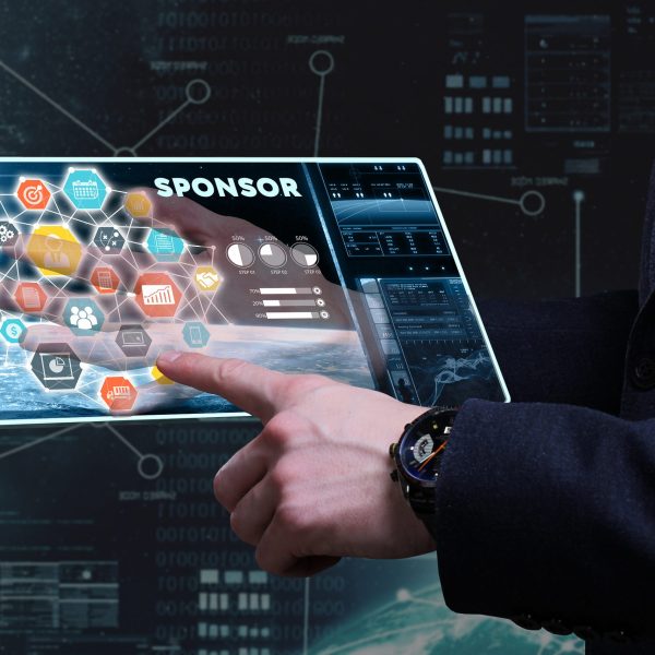 Business Technology Internet and network concept. Young businessman working on a tablet of the future he sees the inscription: sponsor